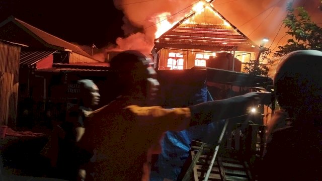 Petugas Damkarmat Makassar dibantu warga dan instansi terkait berusaha memadamkan api yang melalap rumah warga di kawasan pemukiman padat penduduk di Jl Sultan Abdullah II, Kota Makassar, pada Jumat dini hari (31/7/2026). (Foto: BPBD Makassar) 
