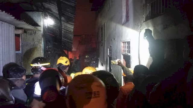 Petugas Damkarmat dibantu warga saat memadamkan api yang membakar rumah warga di Jalan Paccerakang, Makassar, Kamis malam (20/8/2026). (Foto: BPBD Makassar) 
